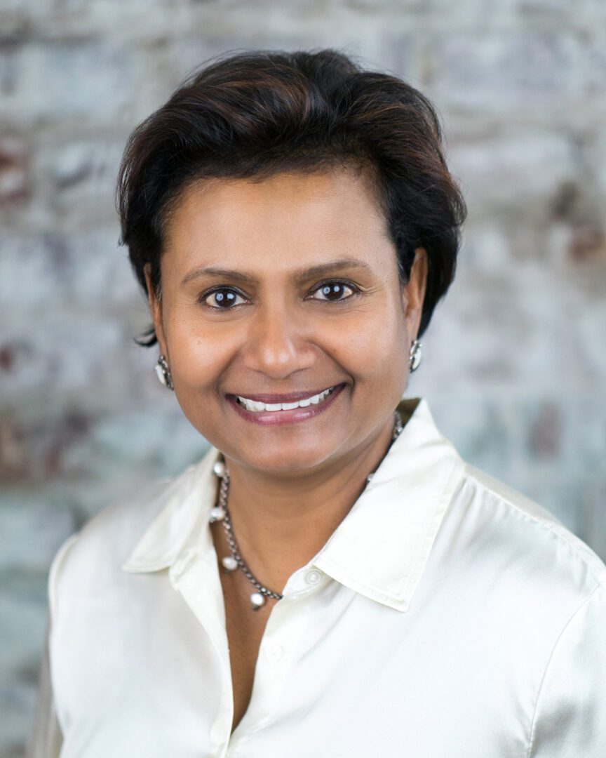 A woman with short hair wearing a white shirt.