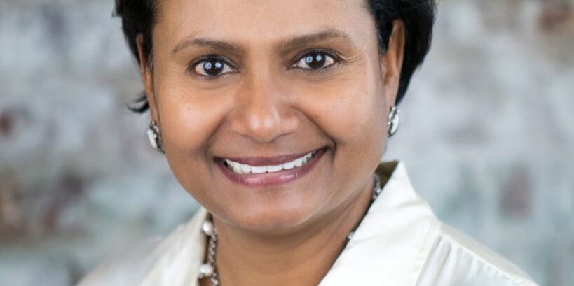A woman with short hair wearing a white shirt.