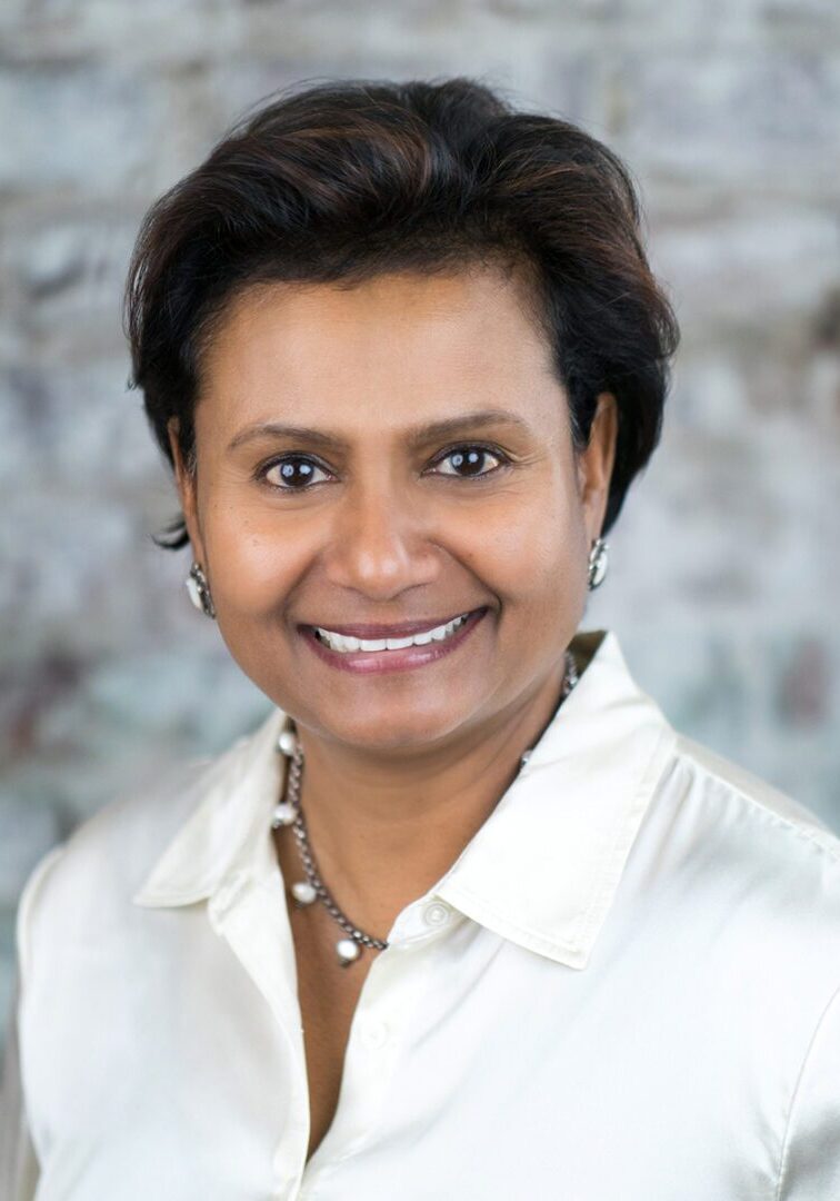 A woman with short hair wearing a white shirt.