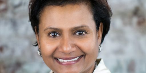 A woman with short hair and wearing a white shirt.