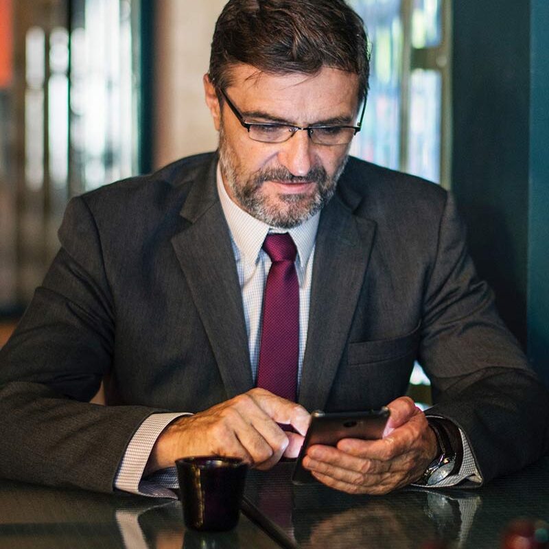 A man in suit and tie looking at his phone.